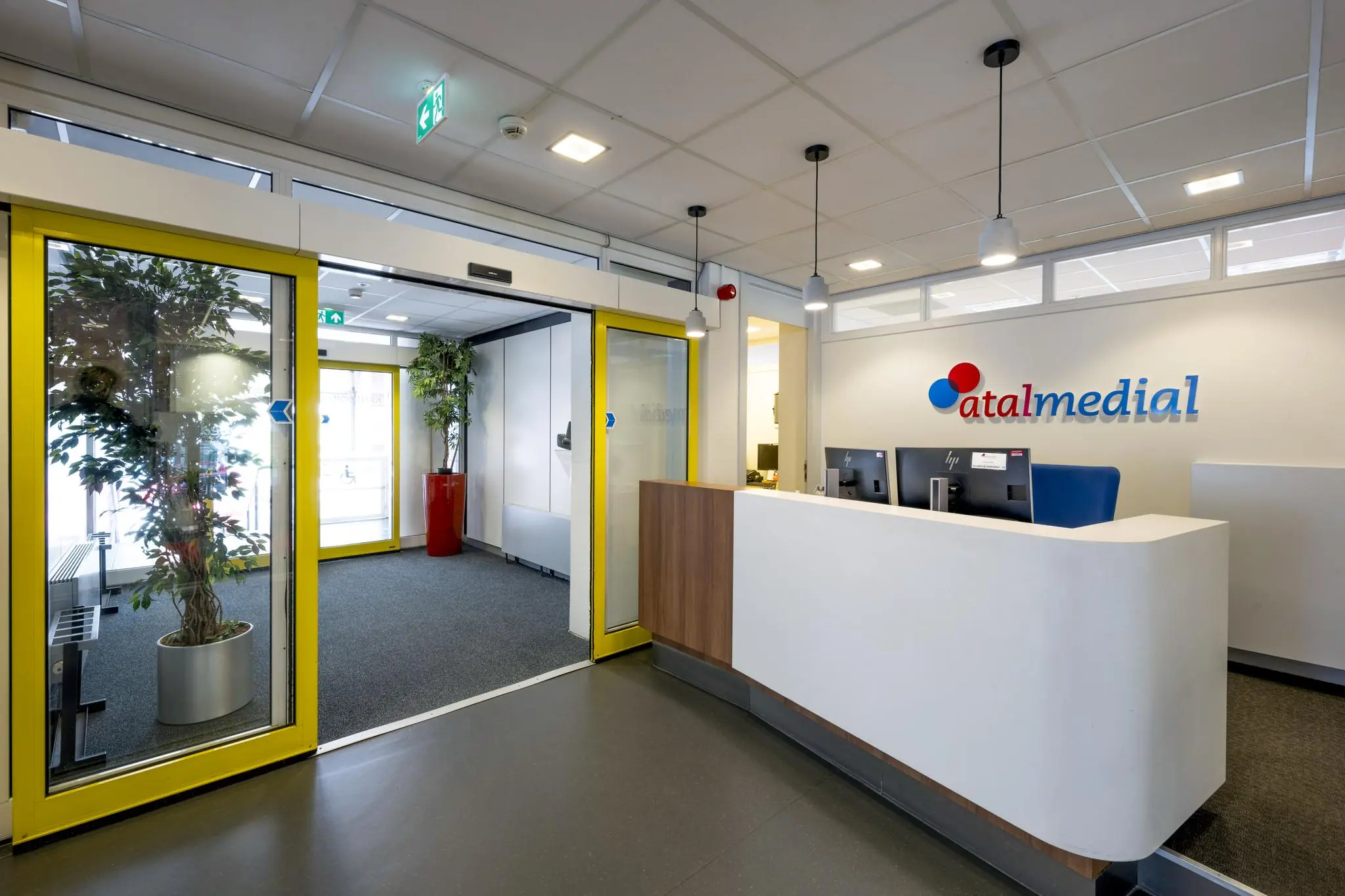 Receptiebalie en entree van Atalmedial aan de Jan Tooropstraat met automatische schuifdeuren en wachtruimte.